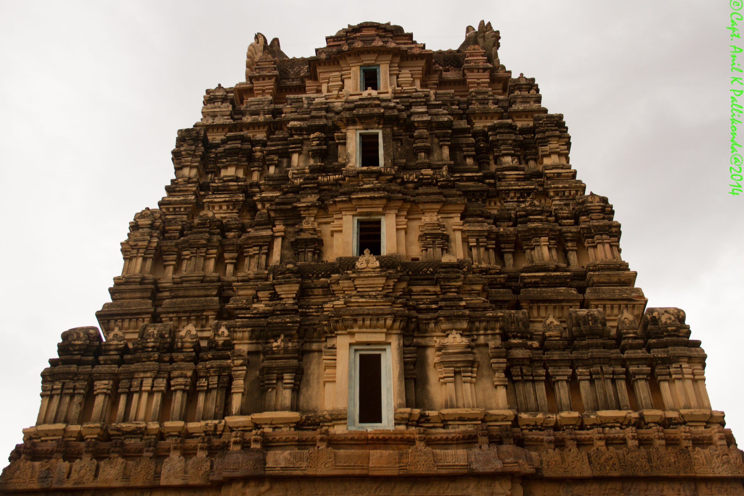 ancient temple, architectural detail, stone carvings, tiered tower, historical monument, Hindu temple, traditional architecture, sacred site, cultural heritage, overcast sky