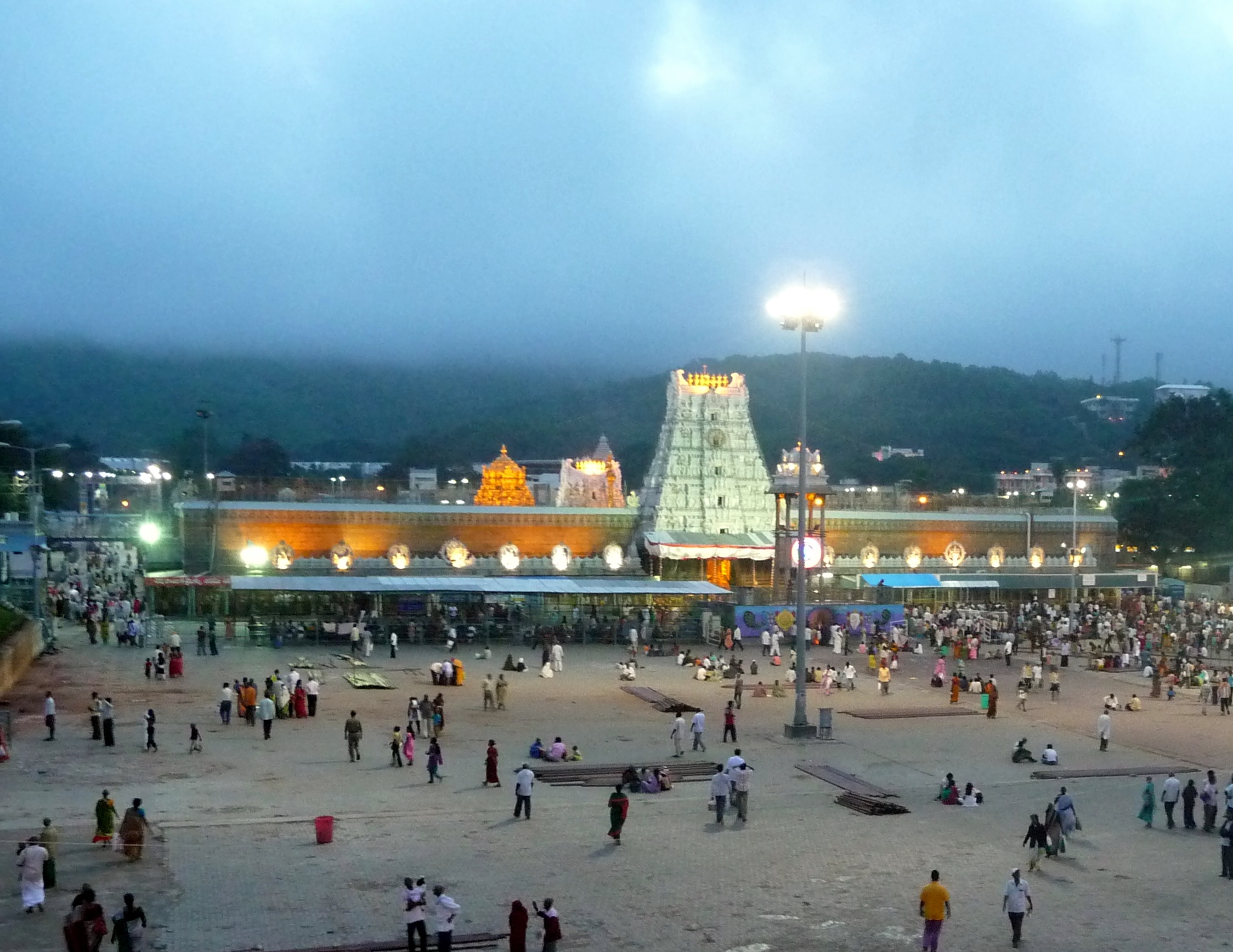 Tirumala Tirupati Devasthanams, TTD Temple, Hindu pilgrimage, temple courtyard, devotees, dusk, temple lights, sacred architecture, pilgrimage site, spiritual gathering