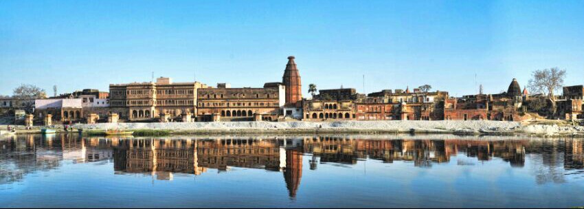 Jugal Kishore Temple, Vrindavan, river reflection, Indian architecture, temple complex, serene landscape, cultural heritage, traditional buildings, panoramic view, clear day