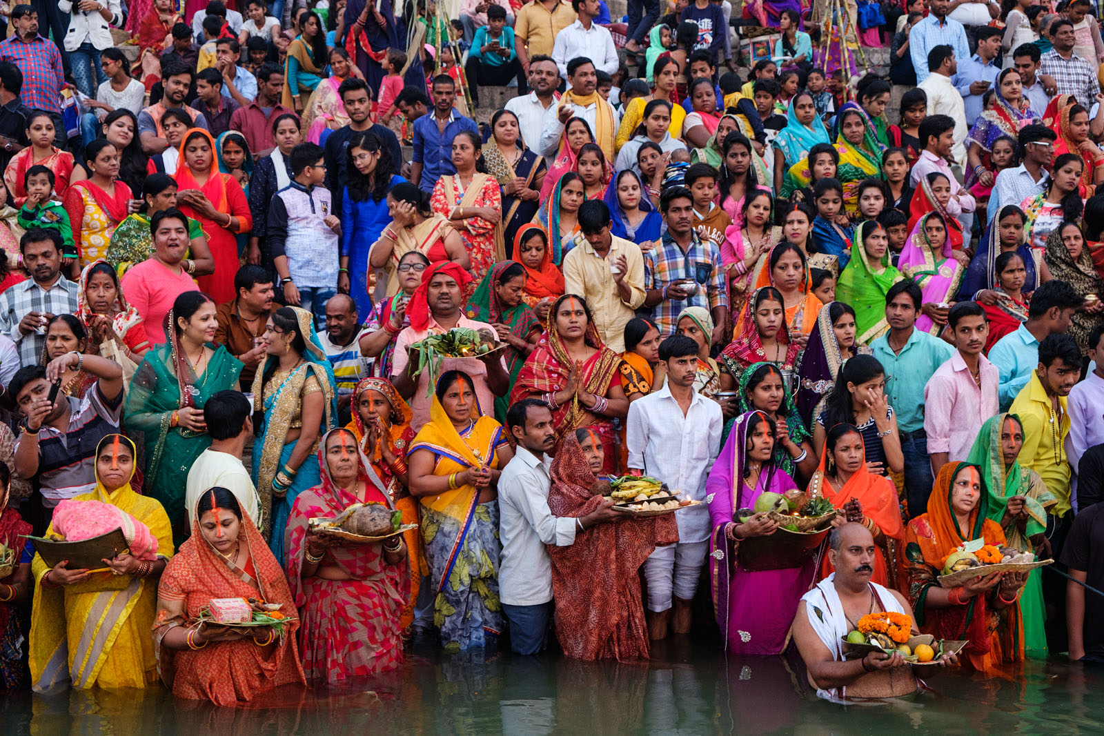 Chhath Puja, Varanasi, religious festival, Hindu worship, traditional attire, river offerings, cultural celebration, communal gathering, festive atmosphere, Indian festivals