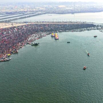 Kumbh Mela, aerial view, river confluence, Prayagraj, massive crowd, spiritual gathering, ceremonial boats, festival, cultural event