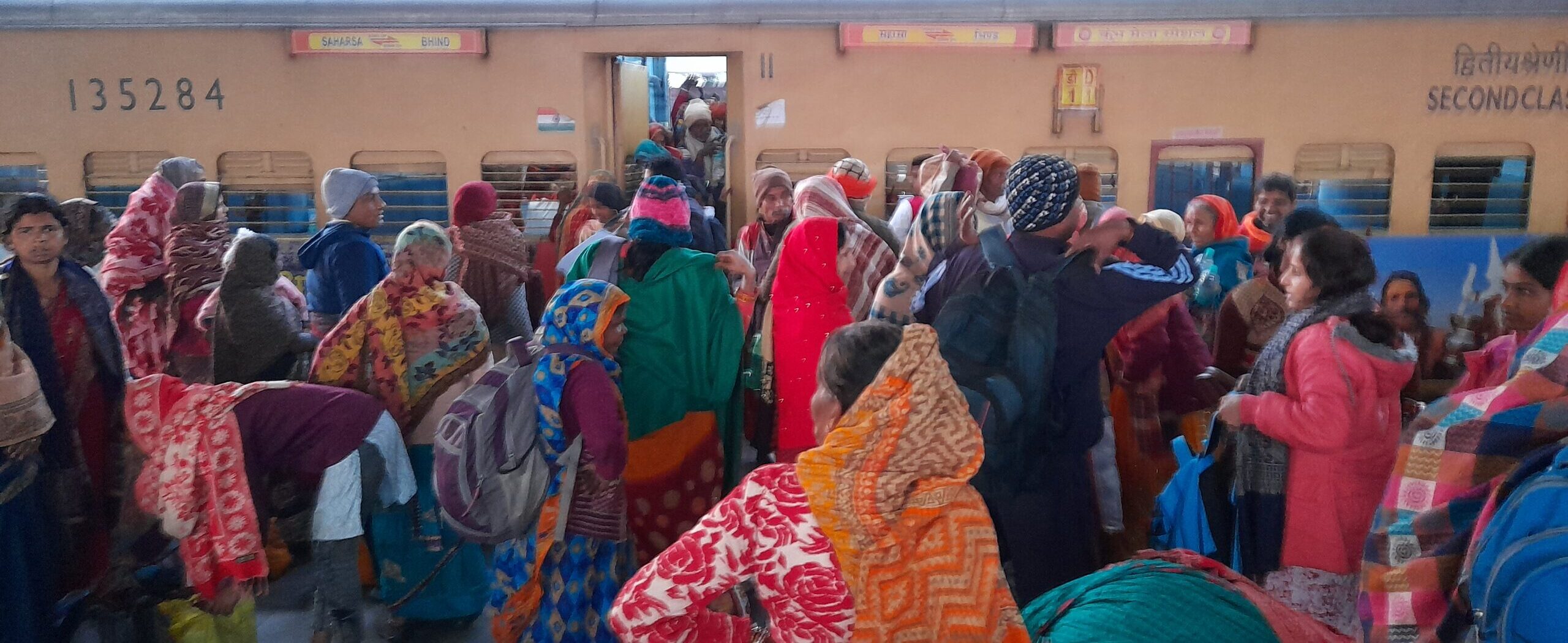 Prayagraj, railway station, crowded train, pilgrim transport, Indian railways, vibrant clothing, travel in India, gender demographics, cultural journey, festival season