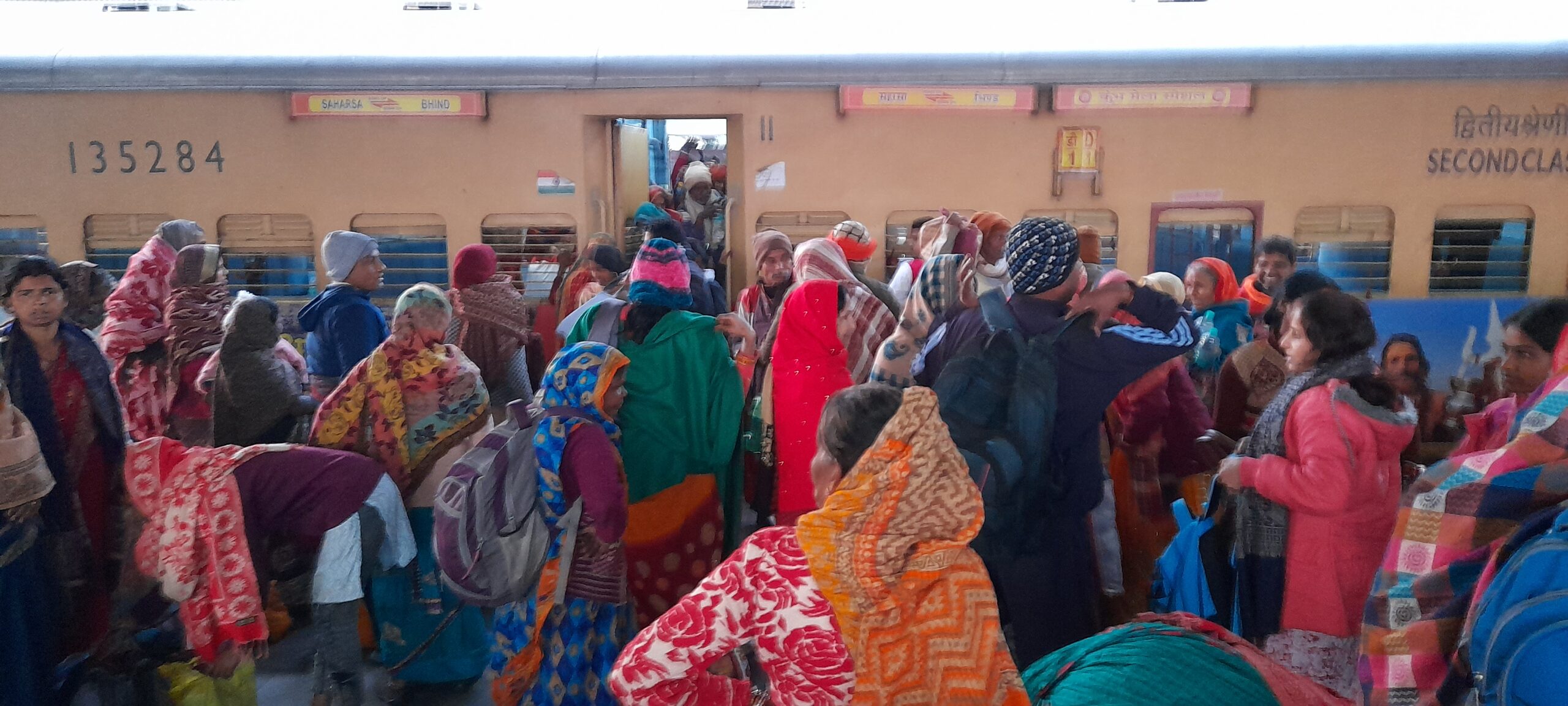 Prayagraj train station, crowded train Mahakumbha 2025, traditional attire, travel in India, cultural journey, passenger movement, vibrant clothing, Indian railways, festival travel, busy